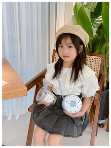 Detail of cute light blue donut crossbody bag with colorful sprinkles on child model
