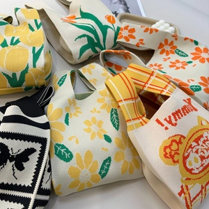 Detail view of colorful knitted tote bags with floral patterns and soft woven texture