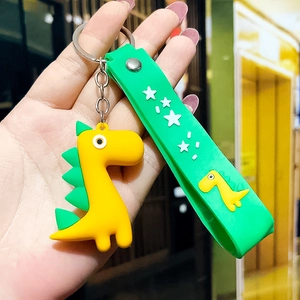 Detail of yellow silicone dinosaur keychain with green strap and silver metal ring