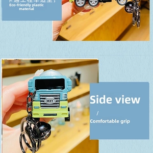 Blue and green dinosaur truck keychain with metal ring and silver bell detail