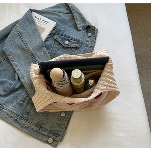 Bolso de punto beige con corazón que muestra capacidad para artículos de uso diario