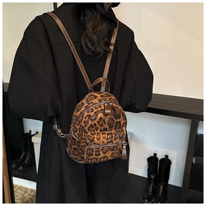 Vista detallada de una mini mochila chic con estampado de leopardo y correas de cuero marrón