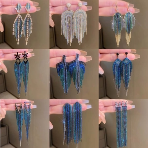 Macro detail of geometric long tassel earrings with sparkling rhinestones set in silver