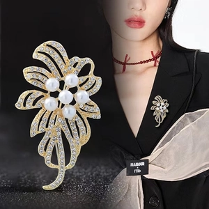 Broche fleur dorée élégante avec perles et strass sur une veste de costume