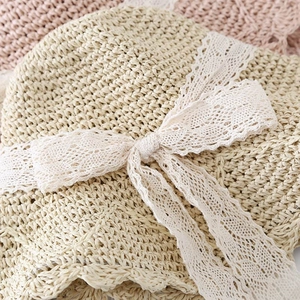 Macro shot of fine woven straw texture and delicate white lace bow on beach sun hat