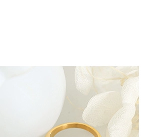 Detailed macro view of a minimalist golden ring on white vessel with flower petals
