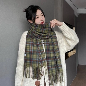 Close-up of green and blue checkered scarf texture with soft fringes and white label
