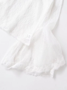 Detailed close-up of white lace flare sleeve with intricate floral texture and eyelash trim