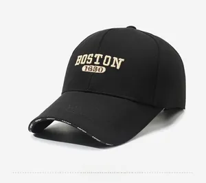 Detail shot of black cotton baseball cap showing beige BOSTON 1630 embroidery and brim text