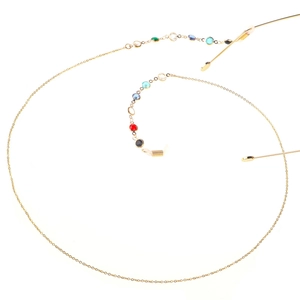 Detail of golden eyeglass chain featuring colorful gemstones on a white background