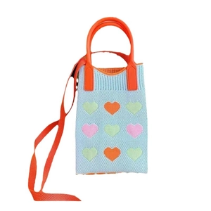 Light blue knitted phone bag with orange straps and colorful heart patterns on white background