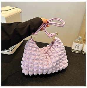 Close-up of purple puff cloud bag featuring textured bubble fabric and gold ring detail