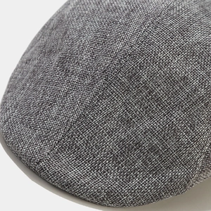 Macro shot of grey linen-textured woven fabric detail on the British style flat cap