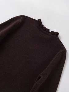 Close-up detail of dark brown knit sweater featuring elegant ruffled collar and fine texture