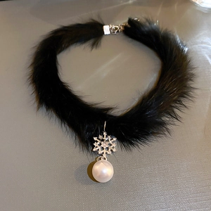 Detail view of black fur choker featuring silver snowflake pendant and pearl bead drop