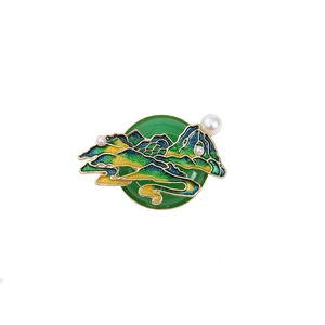 Close-up of Chinese style enamel mountain brooch with green jade base and pearls