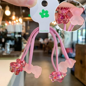 Detail of four pink gummy bear hair ties in matte and glossy resin finishes