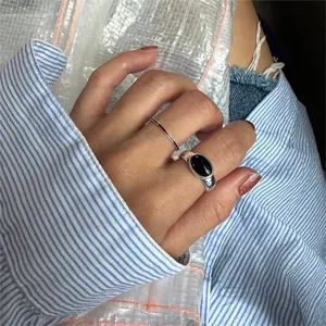 Detail of 925 sterling silver ring set featuring a minimalist band and black oval stone