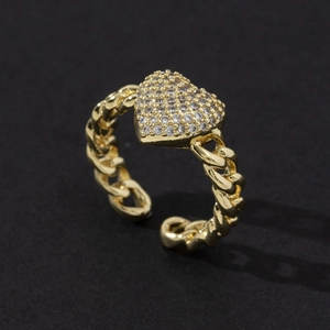 Detail of gold heart ring featuring pave zircons and a textured chain-style band
