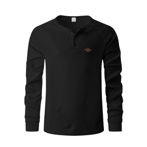 Detail of waffle knit fabric on black long sleeve henley shirt with polyester texture