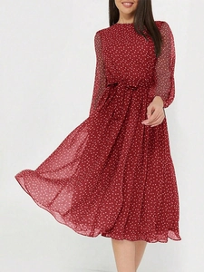 Détail d'une robe d'été rouge à fleurs avec taille à cordon et manches longues
