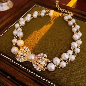 Double-layer pearl necklace with rhinestone bow pendant in vintage luxury style