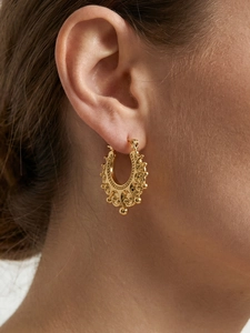 Detail of vintage gold crown U-shaped earring with intricate relief and steel bead design