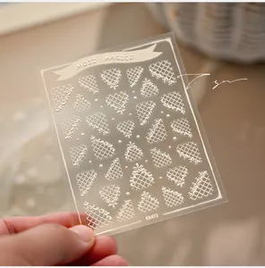 Detailed macro view of 3D embossed white lace and heart pattern nail art stickers