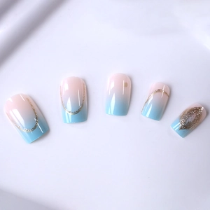 Blue and pink gradient press-on nails with gold glitter and foil line accents