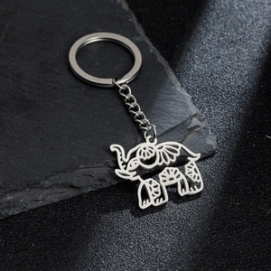 Detailed view of bohemian cutout elephant keychain on a textured dark stone background
