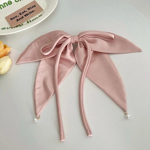 Pink satin bow hair clip featuring elegant long ribbons with delicate pearl pendant details