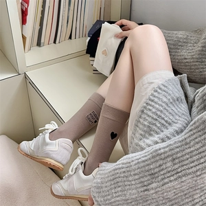 Detailed embroidery of Follow Your Heart text and heart icon on brown cotton socks