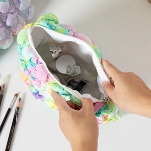 Innenansicht der bunten, gepolsterten Bubble-Kosmetiktasche gefüllt mit Kosmetikartikeln.