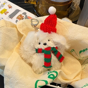 Christmas plush puppy keychain with red knitted hat and striped scarf on soft fabric
