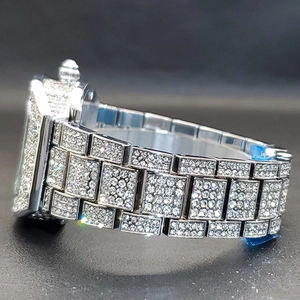Macro side view of silver tonneau quartz watch with full iced-out diamond setting