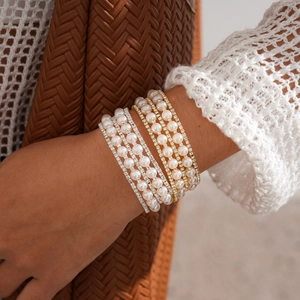Close-up of luxury multi-layer pearl and rhinestone bracelets in gold and silver