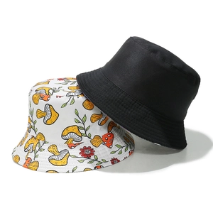 Detail view of reversible cotton bucket hat showing black side and mushroom print pattern