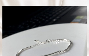 Detailed macro of a polished silver curved metal bar on a classic box chain bracelet