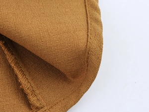 Gros plan sur la texture du tissu jaune brun et les détails de couture de la robe d'été