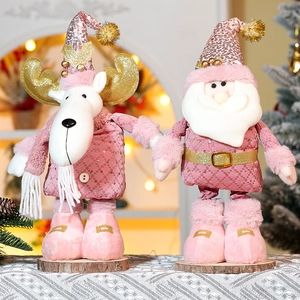 Detailed close-up of pink Christmas dolls with glitter antlers on a rustic wood base