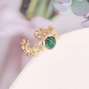 Macro detail of star-shaped cutouts gold ring with green malachite stone inlay