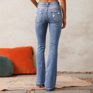 Back view of high-waisted distressed flare jeans with washed blue finish and frayed hems