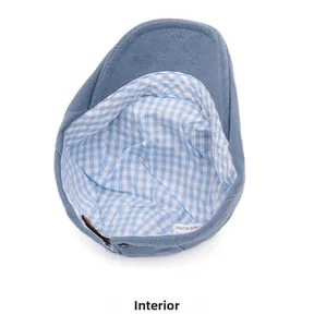 Detail view of cotton corduroy beret interior featuring blue plaid lining and care label
