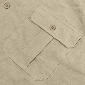 Detail of khaki linen shirt featuring functional flap pocket and durable double stitching