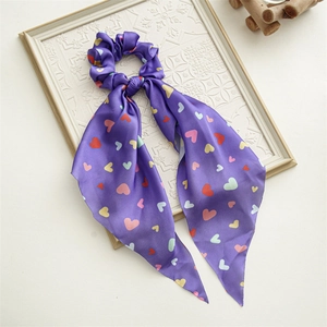 Close-up of purple satin ribbon with colorful heart patterns on a white embossed frame