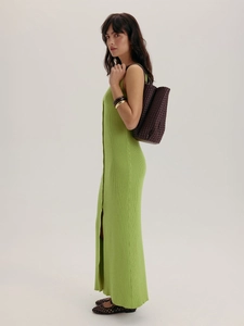 Détail d'une robe en maille vert citron avec une fente latérale et une coupe ajustée