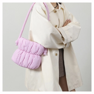 Fashionable light pink quilted puffer bag shown on shoulder for stylish daily wear