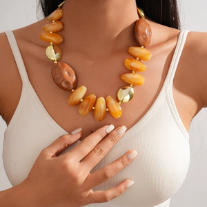 Detailed view of amber acrylic chunky beads and golden spacers on ethnic necklace