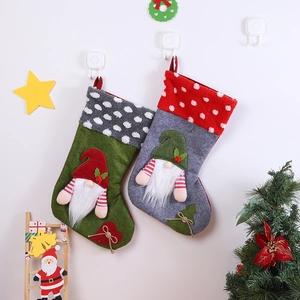 Detail of grey and green Christmas stockings featuring 3D gnome motifs and polka dot cuffs