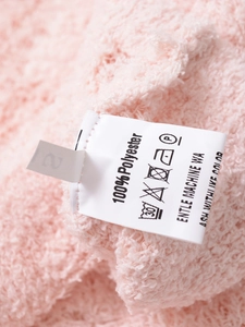 Gros plan sur la maille rose avec étiquette d'entretien et détails du tissu en polyester